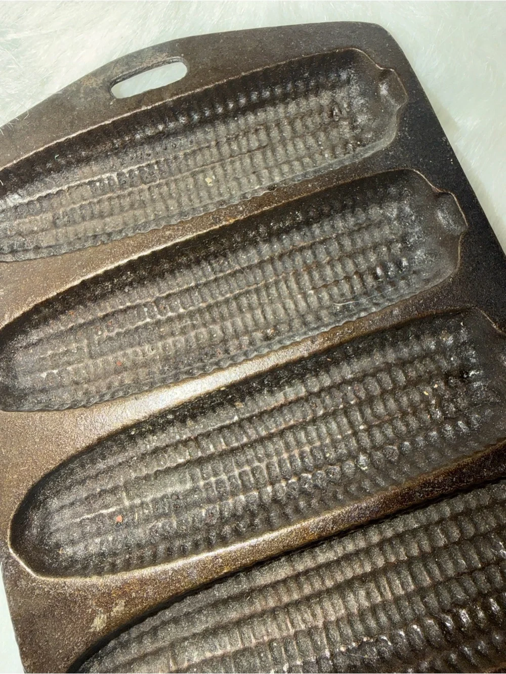Vintage Lodge cast iron corn stick pan with seven corn cob impressions.